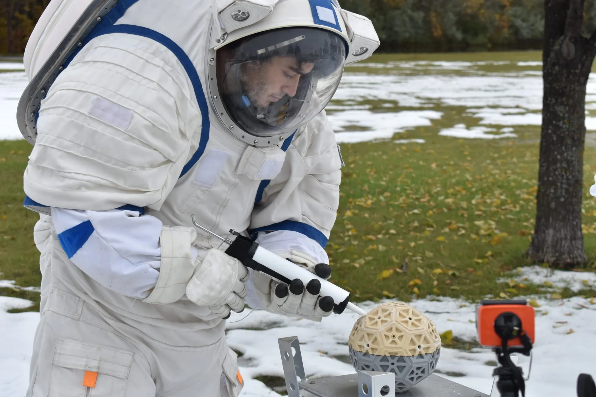 Marcos Bruno runs an experiment wearing spacesuit gloves at ILMAH, in the snow