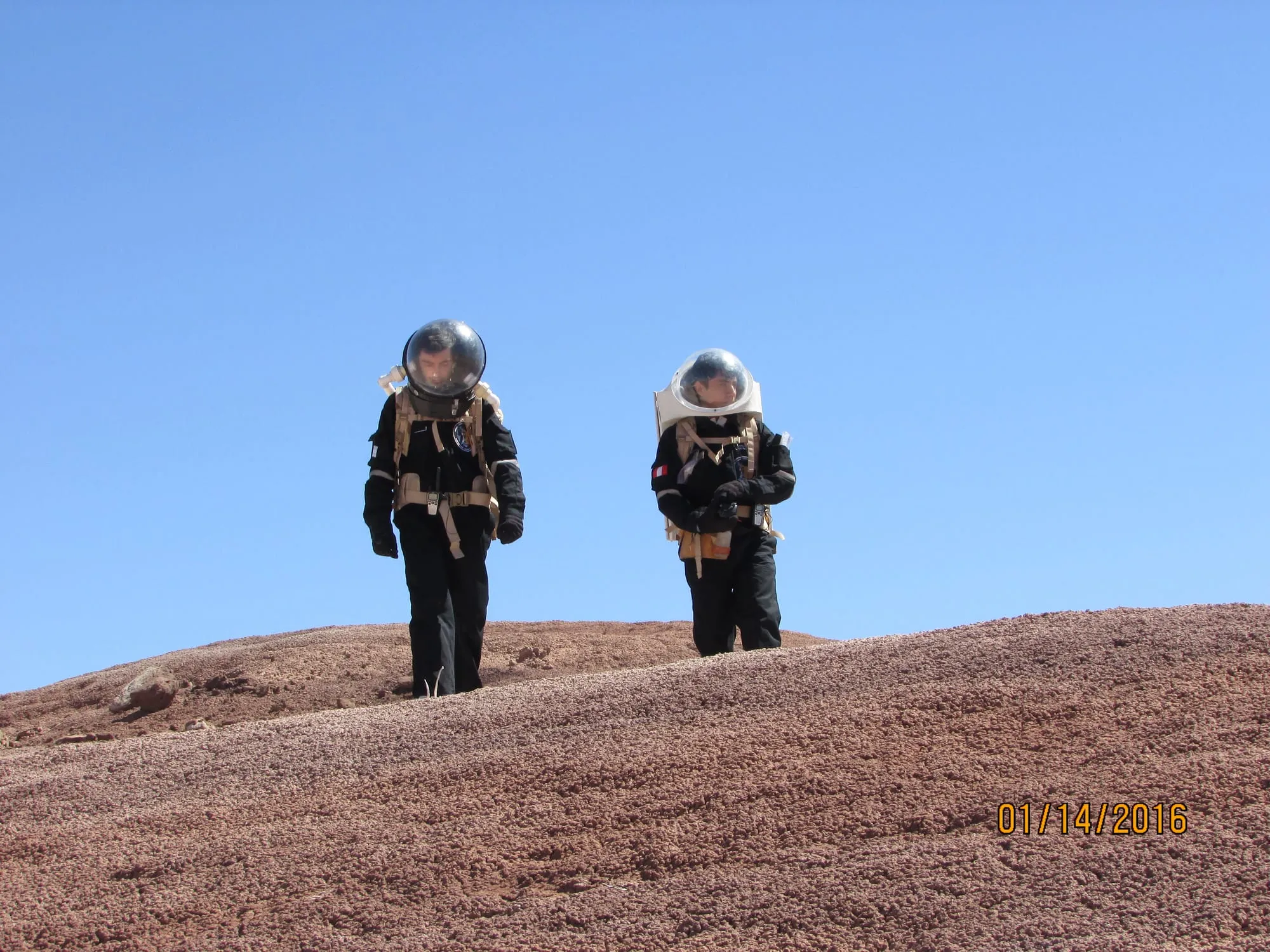 Two analog astronauts walk through the Utah desert during an MDRS simulation