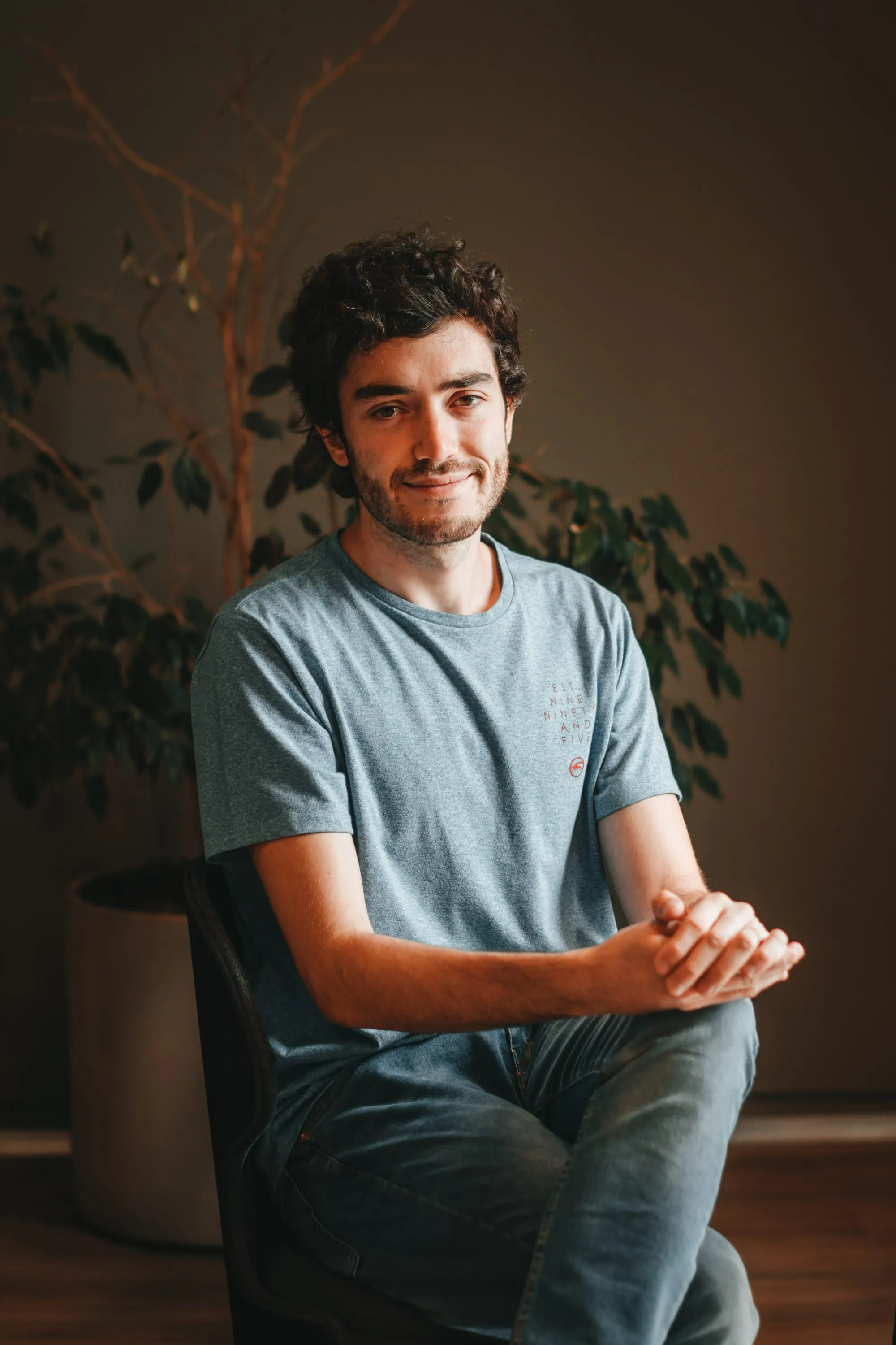 Portrait of Marcos Bruno seated, in a warm setting