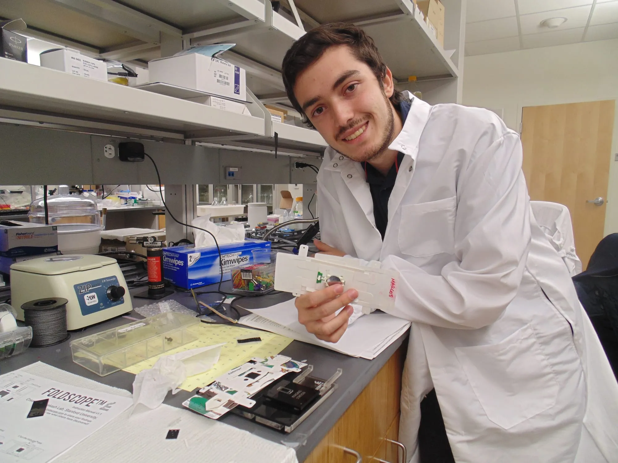 Marcos Bruno at a Stanford laboratory holding a Foldscope